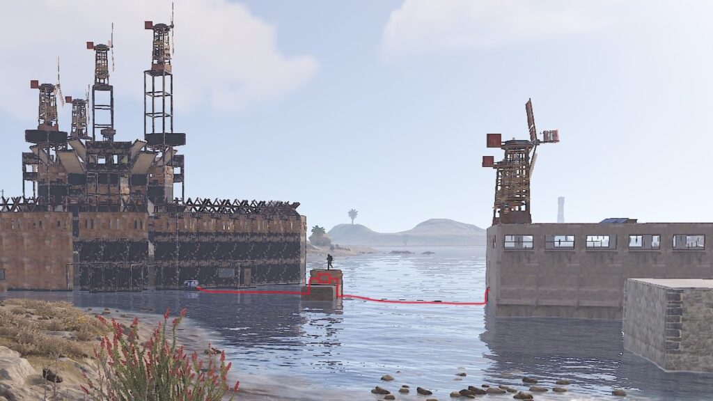 Links die Hafen-Base, rechts die Farmbase, ganz rechts vorn die Bootsbase. Die rote Linie markiert die Versorgungsleitungen. In der Mitte ist ein Umsetzer nötig, weil die Farm zu weit weg von der zentralen Base gebaut wurde.